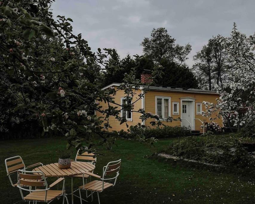 诺拉Lillebo - Centralt mysigt hus i Nora的黄色房子前面的一张桌子和椅子