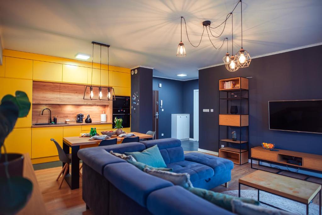 克维曾Apartament Słoneczny的一间带蓝色沙发的客厅和一间厨房