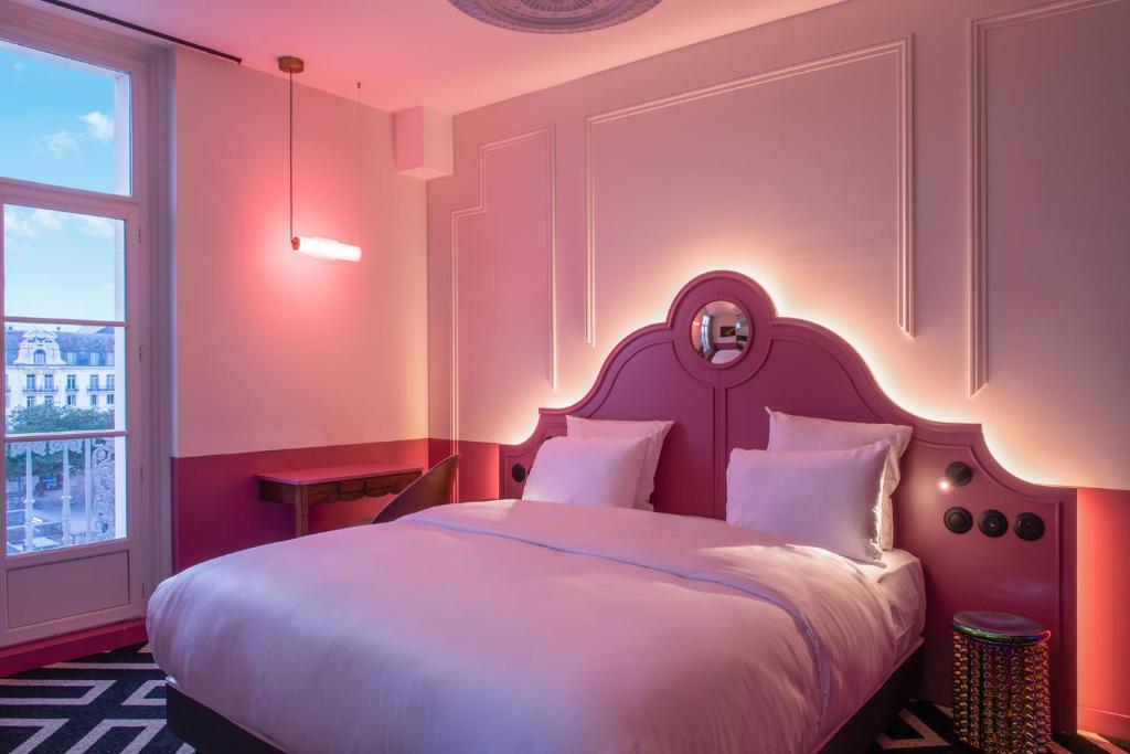 图尔LABE Hôtel Tours Centre Gare的卧室配有一张白色大床和床头板
