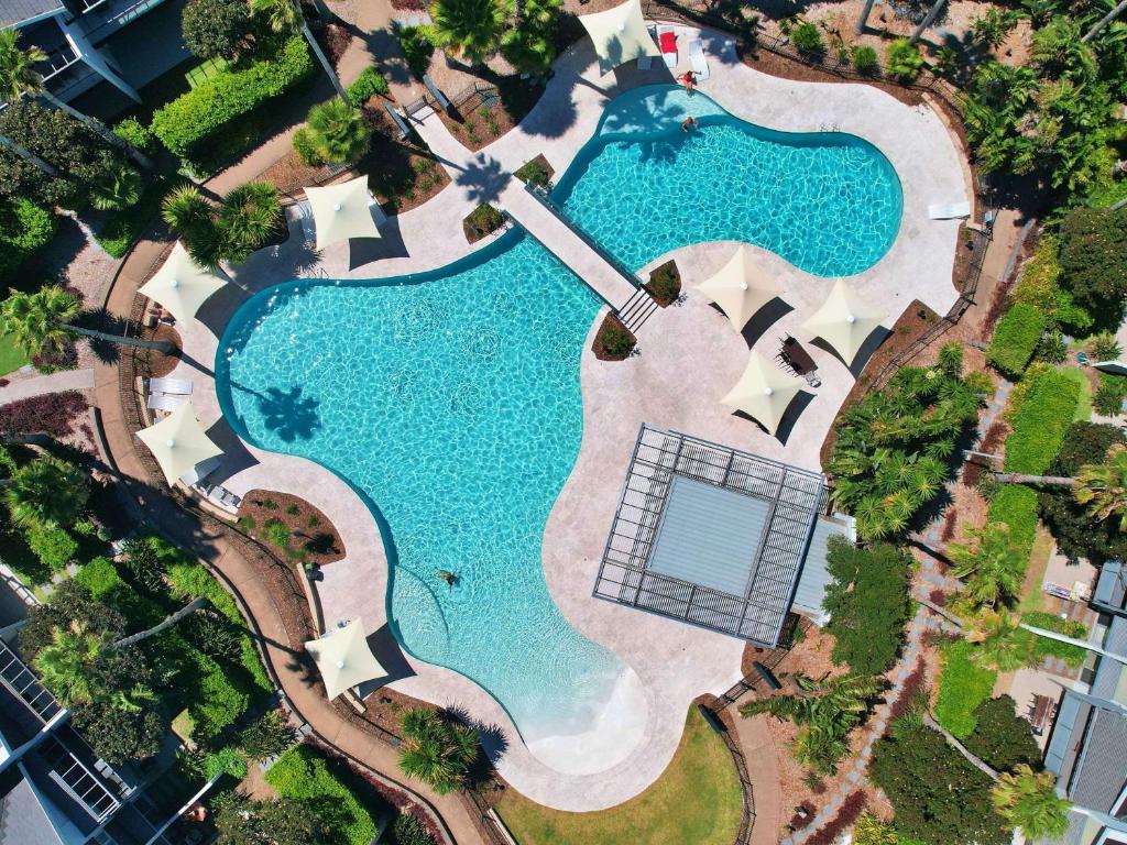 安特兰斯铂尔曼玛格特海滨度假村的享有带网球场的游泳池的顶部景致