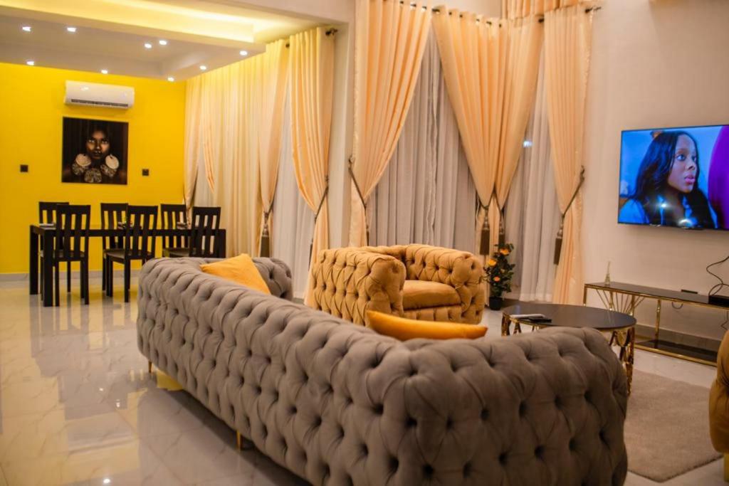 库马西Sleek Luxury Homes的客厅设有大沙发和电视