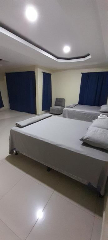 科潘省圣罗莎Espacioso en zona exclusiva的配有两张大床的蓝色窗帘客房