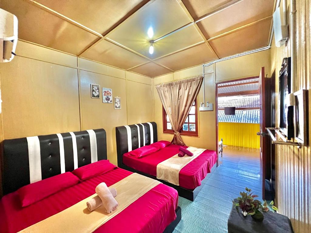 停泊岛Perhentian Sri Tanjung , Pulau Perhentian的红色和黑色的客房内的两张床