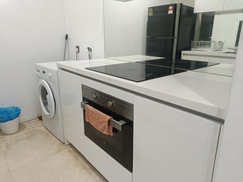 吉隆坡vortex klcc RR的白色的厨房配有炉灶和洗碗机。