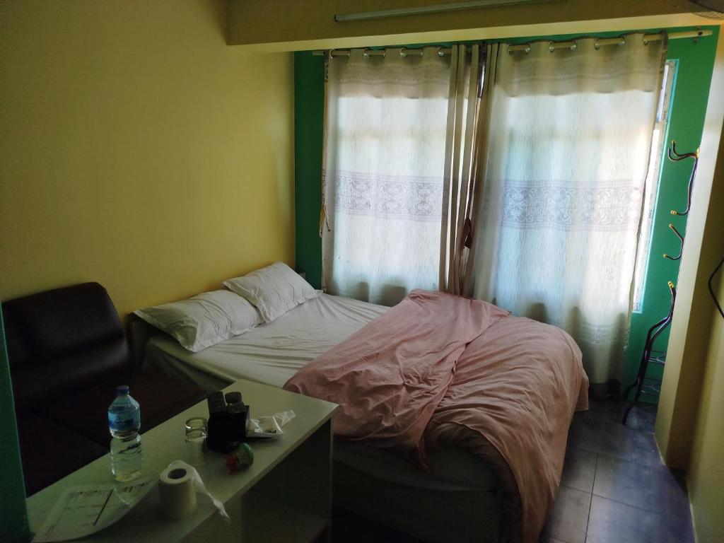 GodāvariGodawari villa guest house的一间小卧室,配有一张床和一张桌子