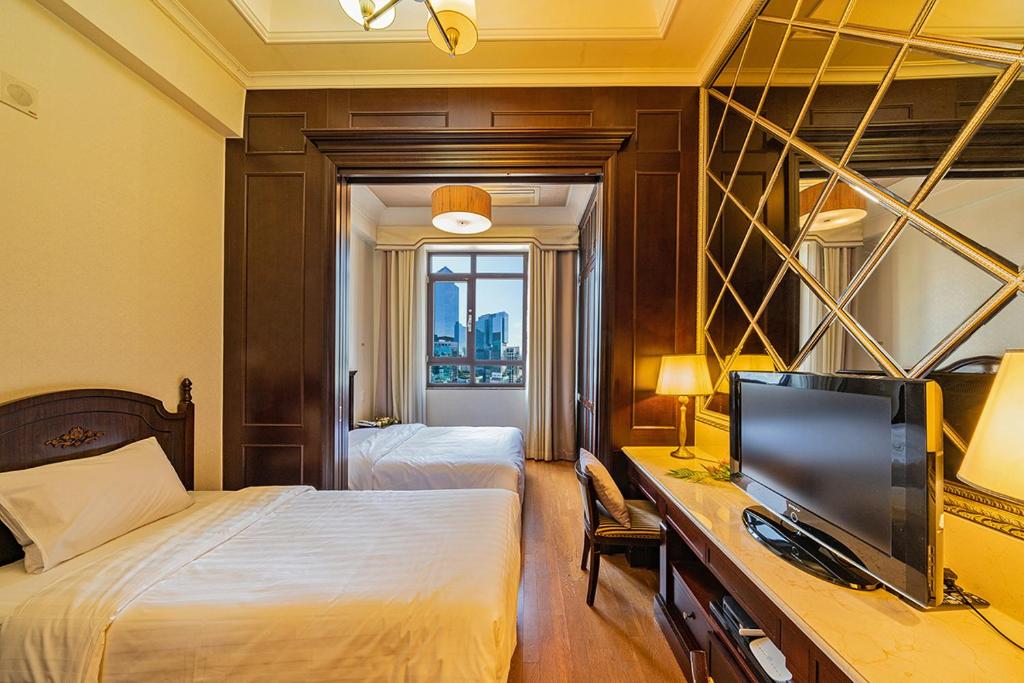 首尔Yeoksam Artnouveau City Hotel and Residence的酒店客房设有两张床和一张书桌及电视