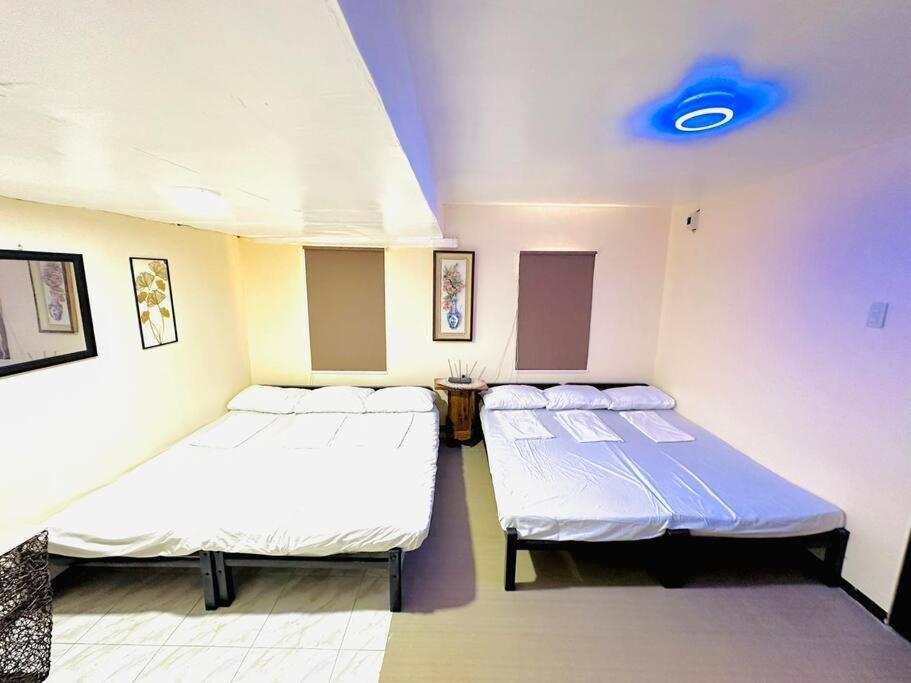 PiliTransient House Camarines Sur Pili的一间设有两张床和蓝色灯光的房间