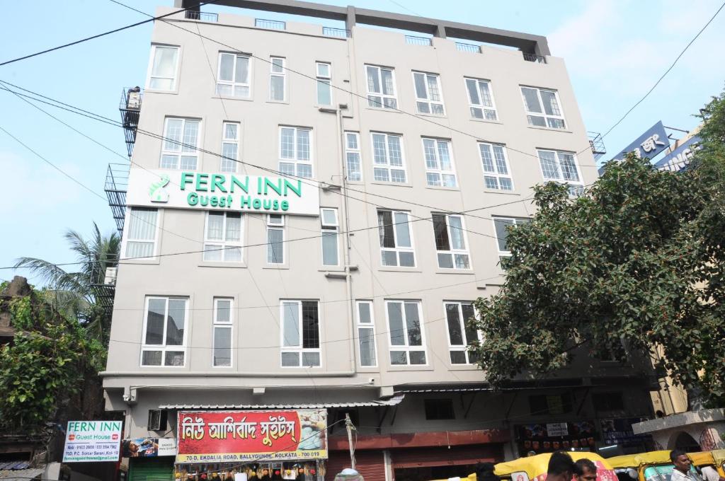 加尔各答FERN INN Kolkata的一座高大的白色建筑,上面有标志
