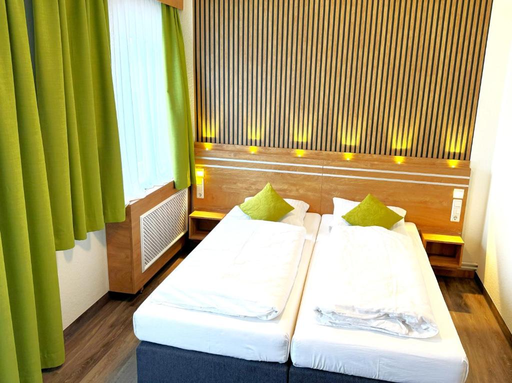 圣安德里斯伯格Berghotel Glockenberg的绿窗帘间内的两张床