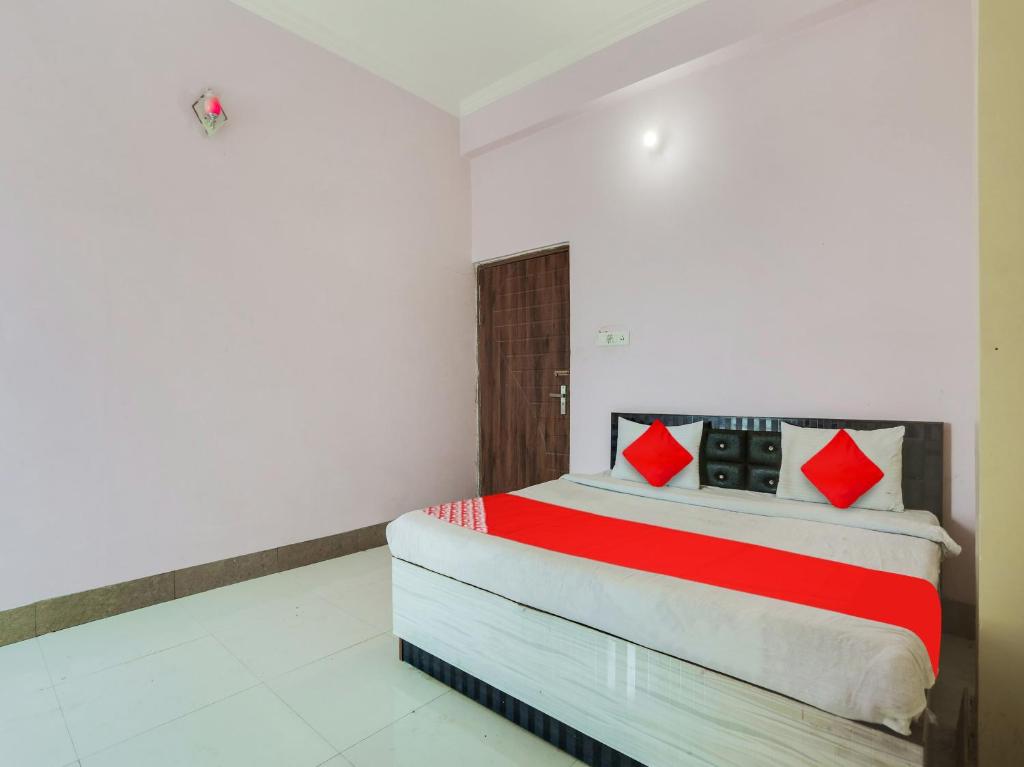 坎普尔OYO Flagship Radhe Radhe Hotels的一间卧室配有一张带红色枕头的床