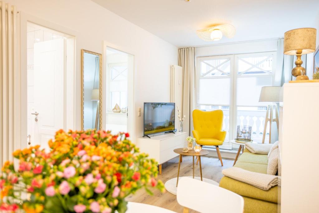 宾茨Fewo Auszeit im Haus Strandburg的客厅配有黄色椅子和沙发