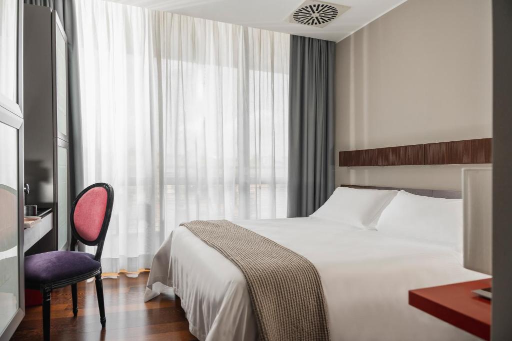 圣马力诺Welcome Hotel的卧室配有床、椅子和窗户。