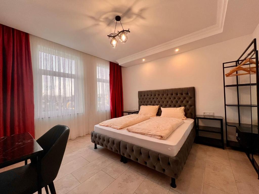 汉诺威Durmaz Hotel的一间卧室配有一张带红色窗帘的大床