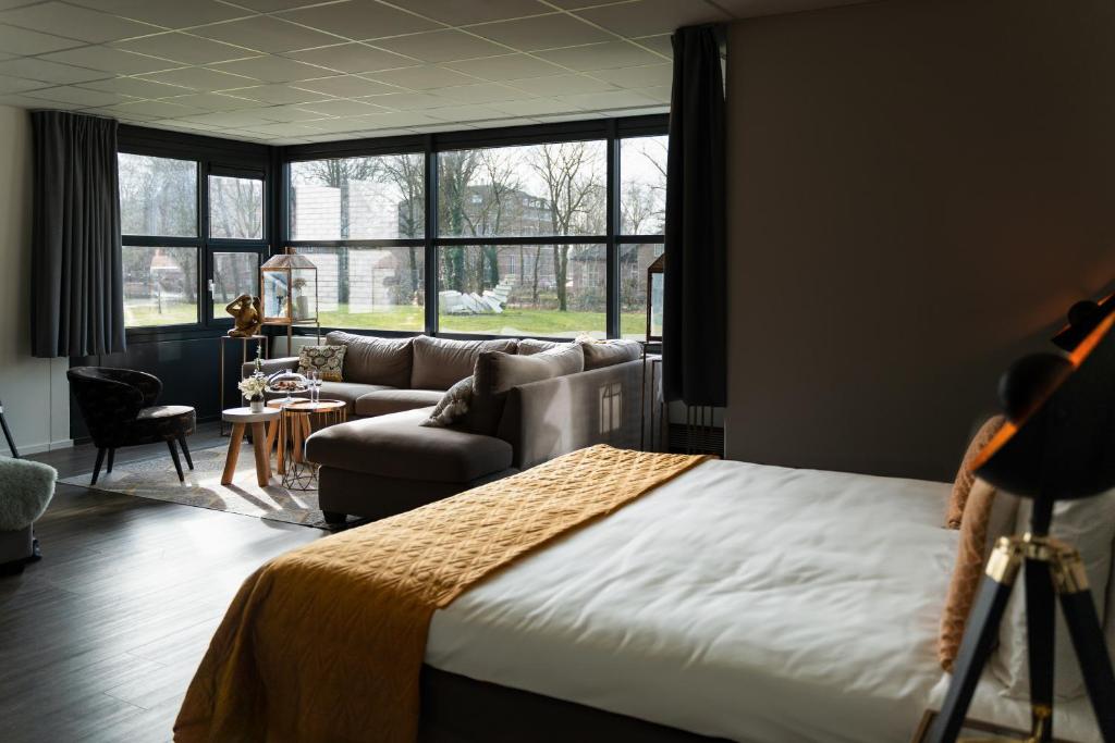 瓦赫宁根Hotel WICC的一间卧室配有一张床、一张沙发和一张桌子