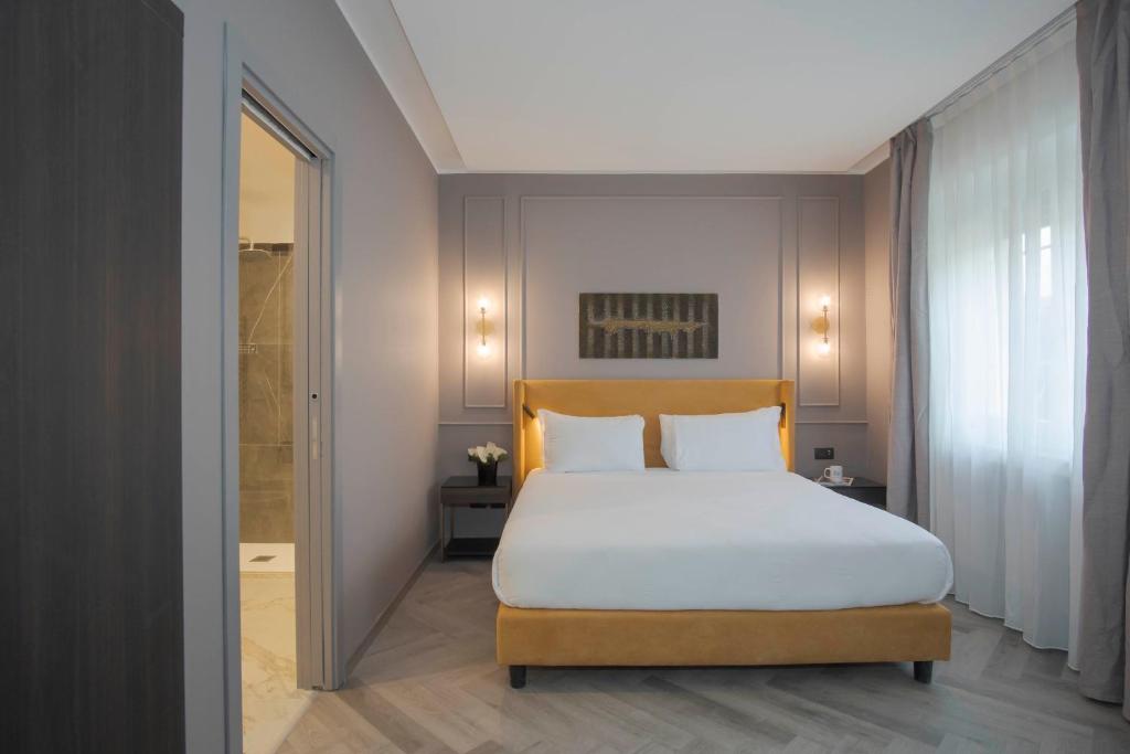 罗马维米纳勒酒店的一间卧室设有一张大床和淋浴