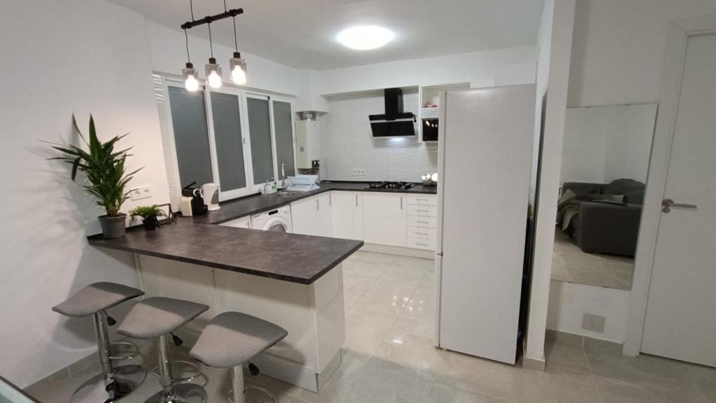 福恩吉罗拉FUENGIROLA CENTRO的白色的厨房,配有柜台和凳子