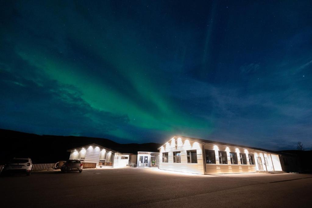 斯科加尔弗斯Hótel Skógafoss by EJ Hotels的一座晚上在天空中呈现极光的建筑
