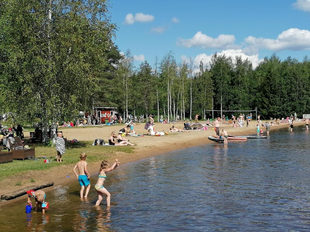PyhäjärviEmolahti Camping的一群人在海滩上玩水