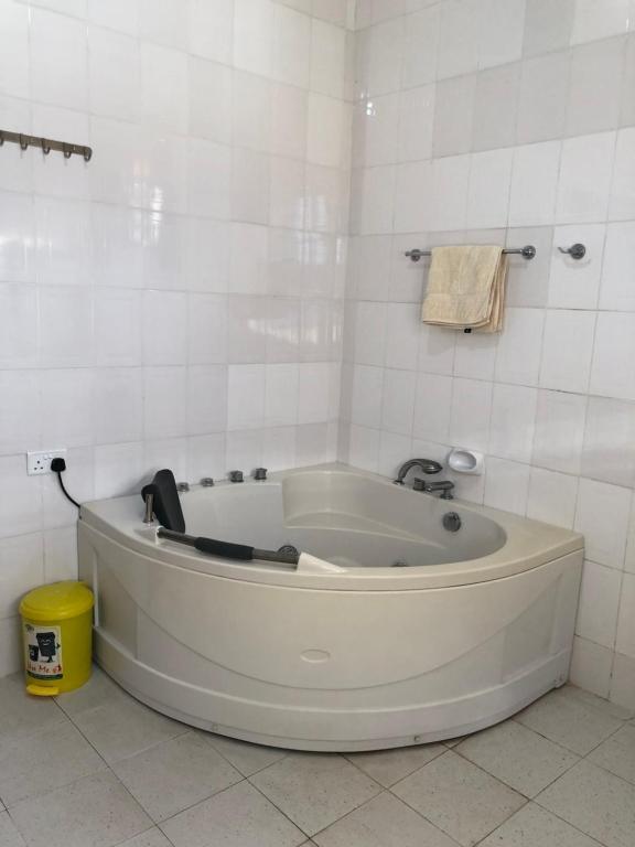 达累斯萨拉姆Jambo hostel tz的白色瓷砖浴室内的白色浴缸