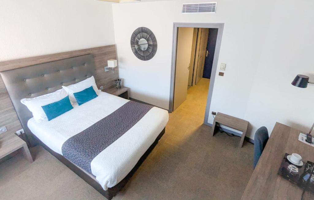 热纳KYRIAD LYON EST - Genas Eurexpo的一间卧室配有一张带蓝色枕头的床和一张桌子