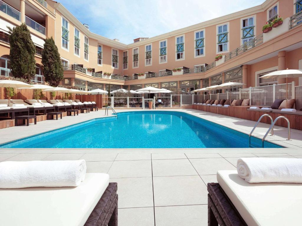 普罗旺斯艾克斯Grand Hôtel Roi René Aix en Provence Centre - MGallery的一座带椅子的酒店游泳池,一座建筑