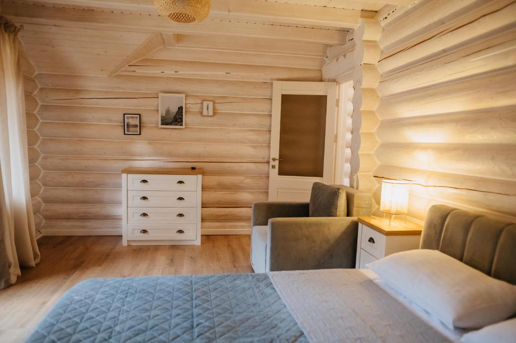米库利钦Vila Mila的卧室设有木墙、一张床和一个梳妆台