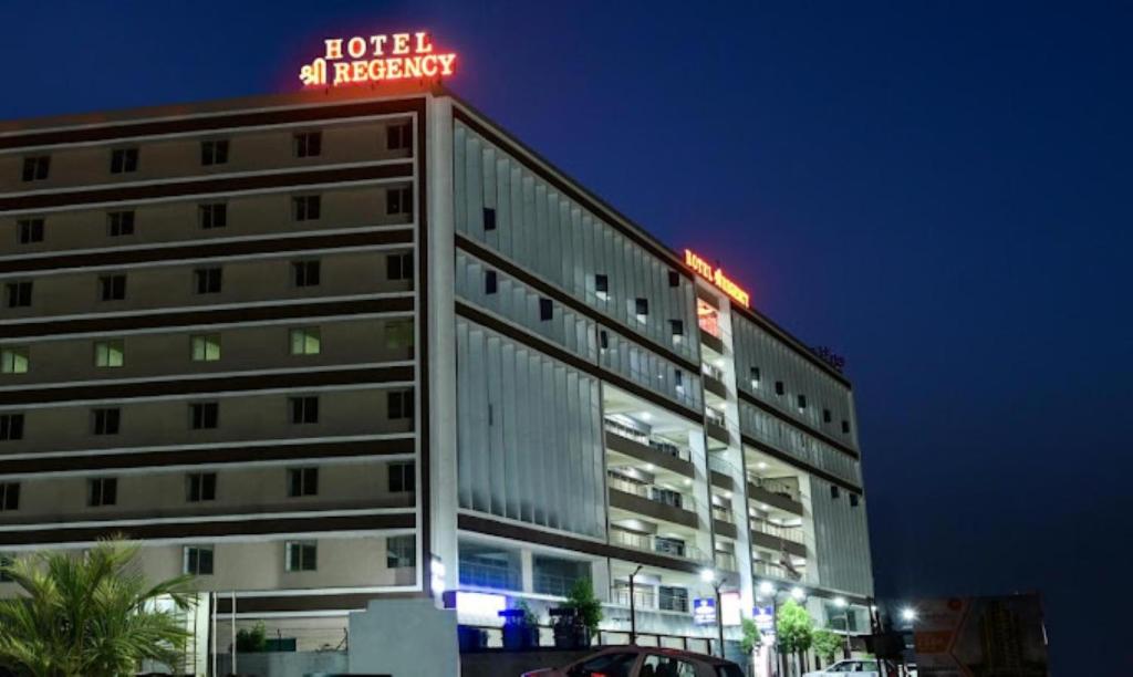 艾哈迈达巴德Hotel Shree Regency Ahmedabad的上面有 ⁇ 虹灯标志的建筑