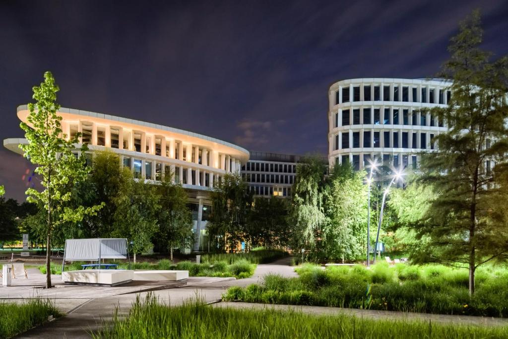 华沙声音花园机场酒店的一座建筑,在晚上前有一个公园