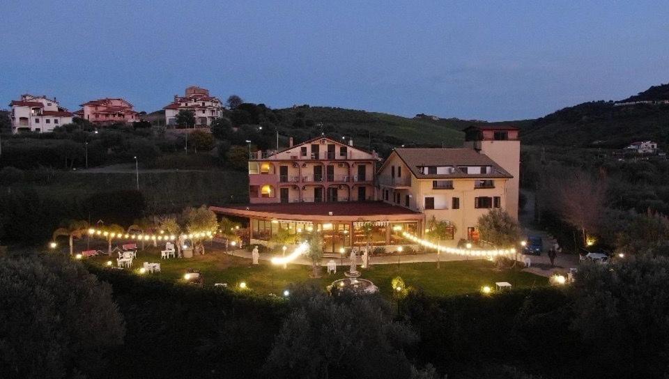 MirtoAgriturismo Fonte Madonna的一座大建筑,晚上在院子里有灯