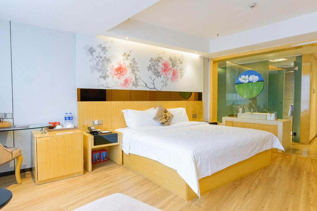 广州Paco Hotel Tuanyida Metro Guangzhou -Free ShuttleBus for Canton Fair的一间卧室配有一张大床和一张书桌