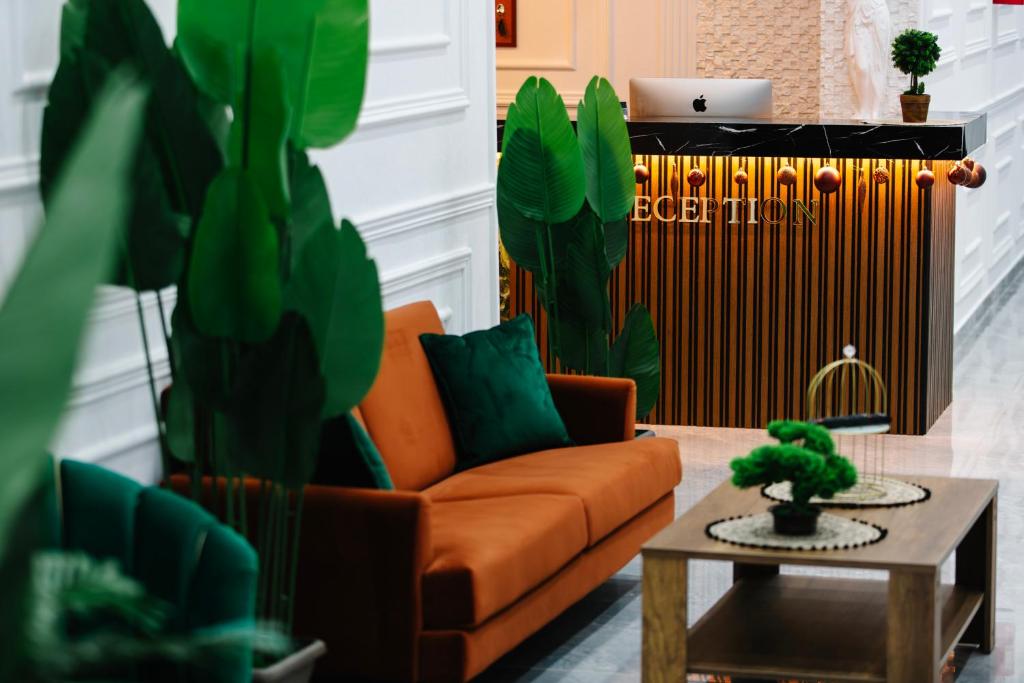 都拉斯Andor Luxury Hotel的客厅配有橙色沙发和桌子