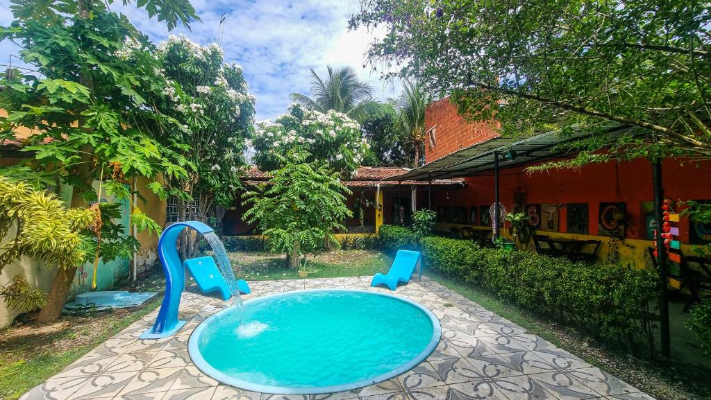 马塞约Proxima Estacion Hostel的院子里一个带两把蓝色椅子的游泳池