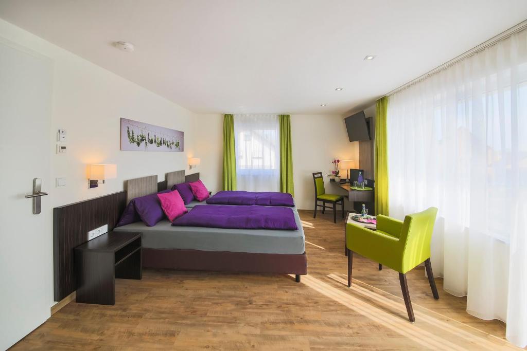 腓特烈港Hotel Gästehaus Stock的一间卧室配有一张紫色的床和一张绿色椅子