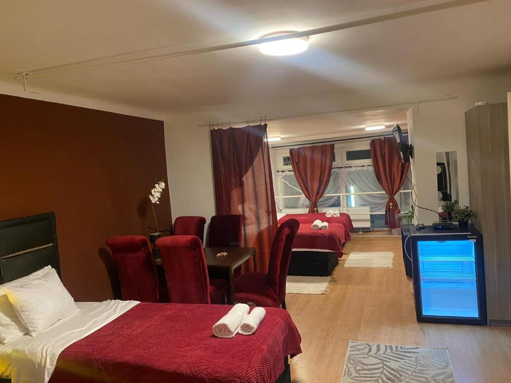 布达佩斯Allaga House的酒店客房带两张床和一张桌子以及椅子。