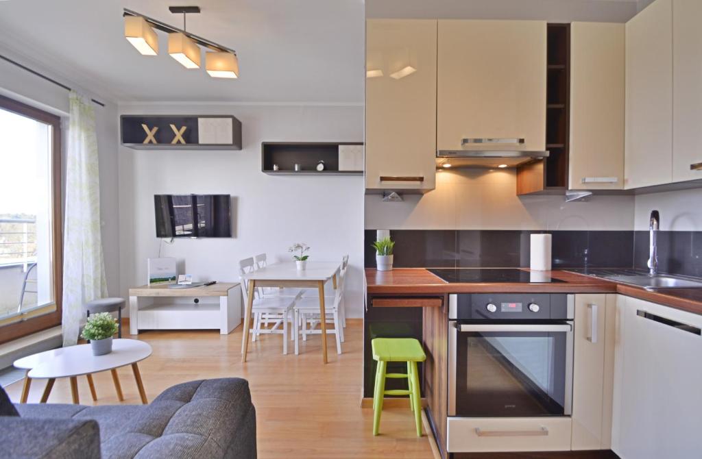 斯维诺乌伊希切Platan - Apartamenty Bryza的厨房以及带沙发和桌子的客厅。