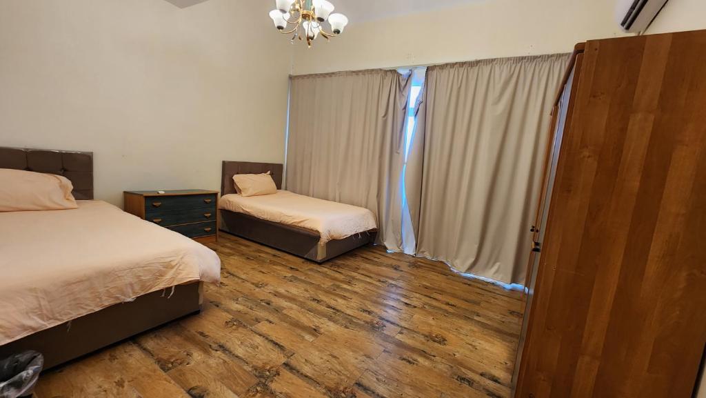 杜拉特阿拉尔فيلا بمسبح خاص و شاطئ رملي في درة العروس的一间卧室设有两张床和窗户。