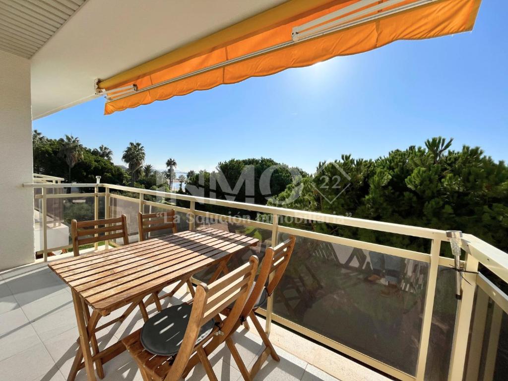 坎布里尔斯Apartamento frente al mar en La Llosa Edif Olimpic 103A - INMO22的阳台的甲板上配有木桌和椅子