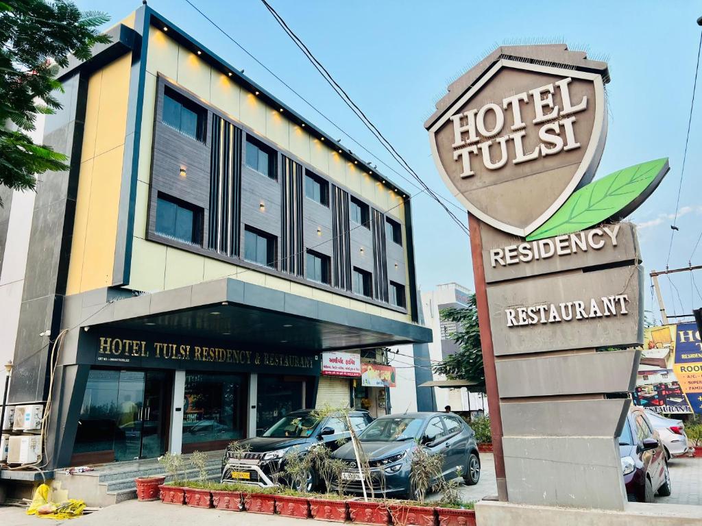 普杰Hotel Tulsi Residency的建筑前有标志的酒店