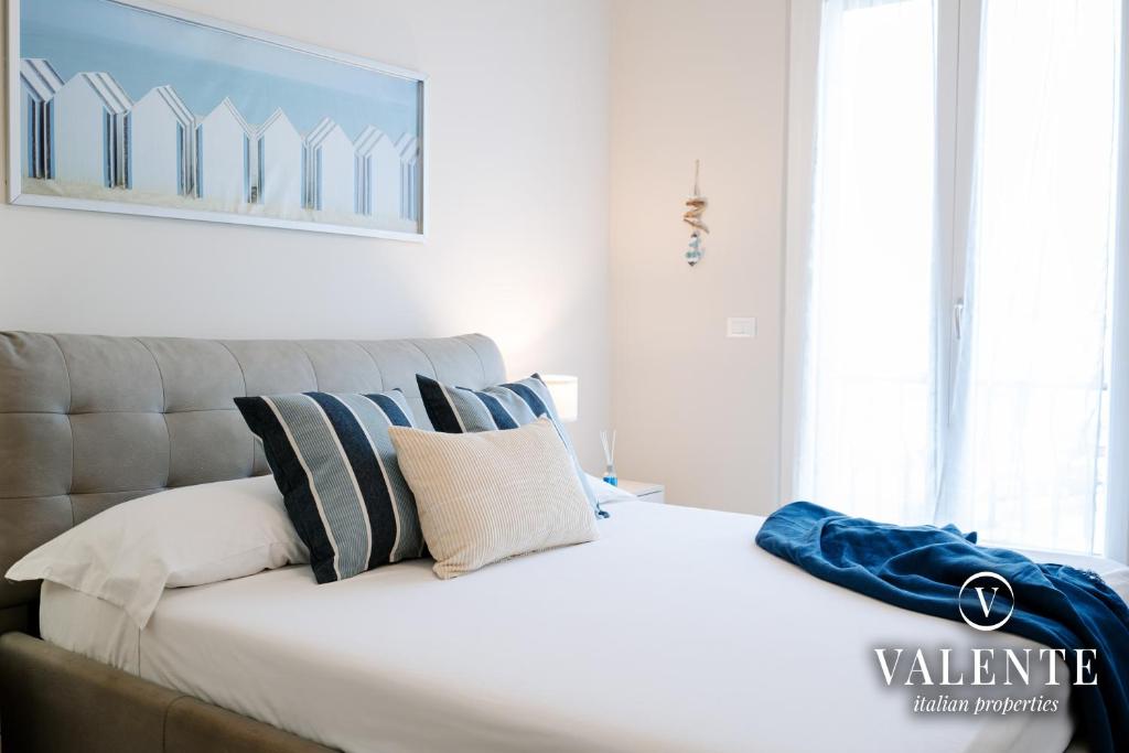 维亚雷焦Viareggio - Via Pisano 61 Valente Italian Properties的卧室配有带枕头的大型白色床