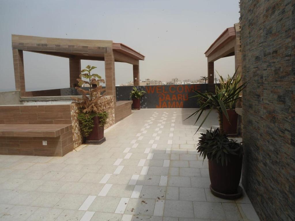 达喀尔Daaru Jamm的一座种植了盆栽植物的庭院和一座建筑上的标志