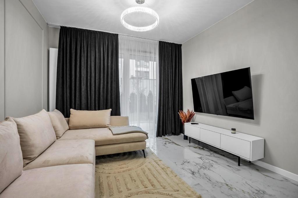 华沙Airport Apartment - Private Terrace & Parking - by Rentujemy的带沙发和平面电视的客厅
