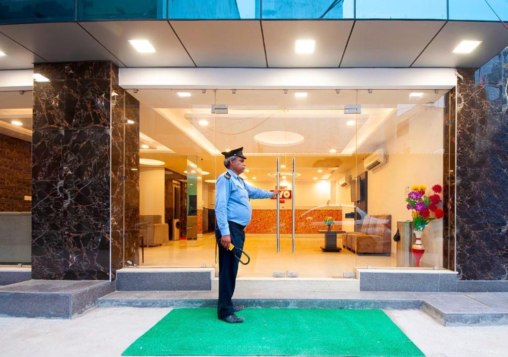 新德里Hotel Bellwood Grand Near Delhi IGI Airport的身着毕业帽的人站在绿色地毯上