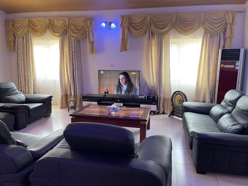 阿克拉AGASTEV Guesthouse GH的一位站在带电视的客厅的女人