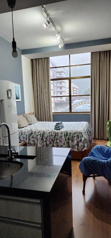 特雷索波利斯Loft no Alto的客房设有两张床、一张桌子和一扇窗户。