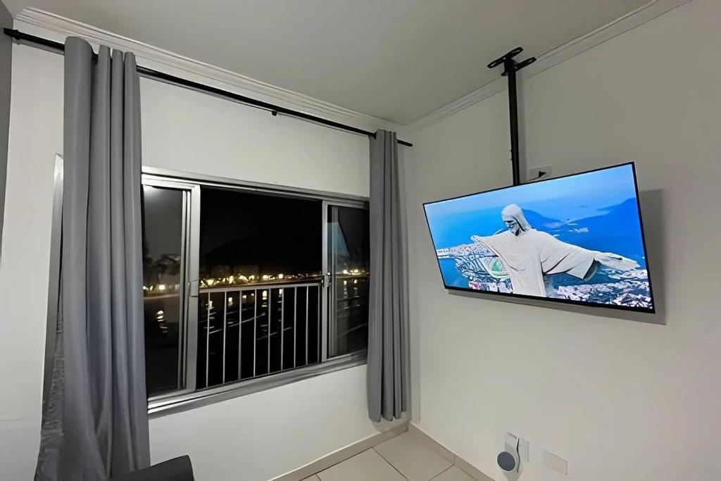 圣维森特岛Apartamento *Vista da Ilha* - Novo Lançamento!的挂在窗户旁墙上的平面电视