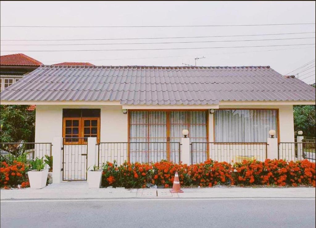 Bang HiaMee-Suk Home的前面有围栏和鲜花的房子