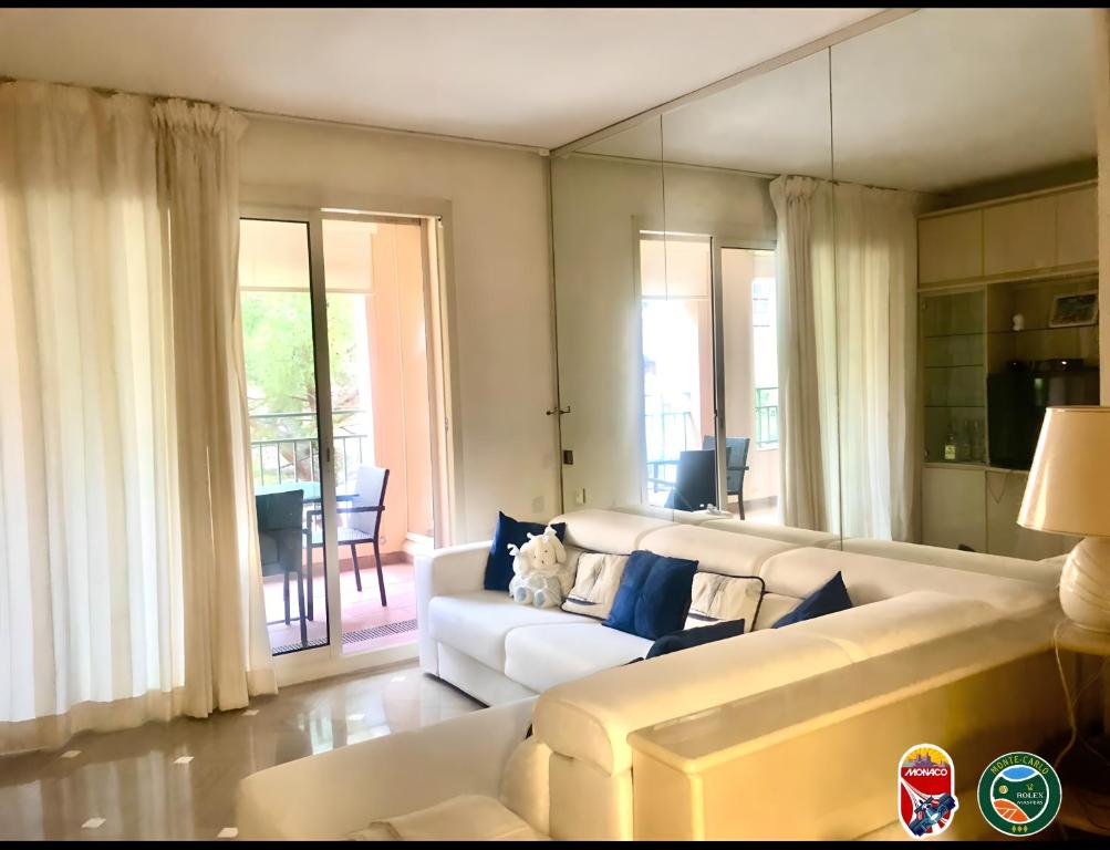 蒙特卡罗Monaco Fontvieille Port - refined apartment overlooking garden - open air swimming-pool的客厅配有白色的沙发和桌子
