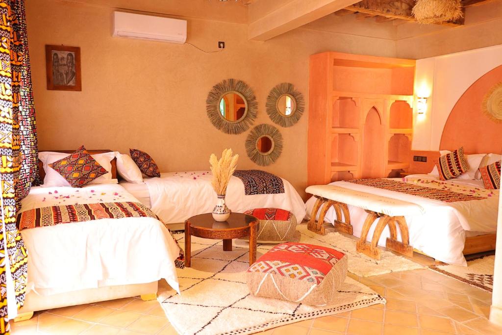 扎古拉riad dar susan的客房设有两张床、一张桌子和镜子。