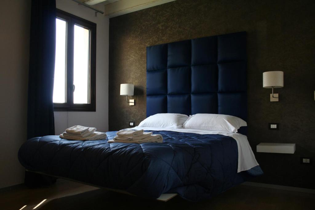 阿格里真托班布奢华住宿加早餐旅馆的一间卧室配有一张大床和蓝色床头板