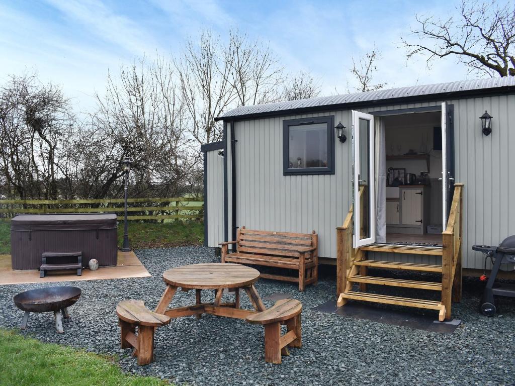 GilcruxGreengill Farm Shepherds Hut- Ukc3632的一个带野餐桌和长凳的小棚子